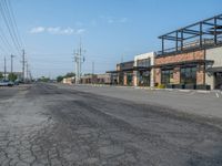 the empty street outside of the business district is empty and deserted with vehicles parked in it