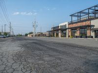 the empty street outside of the business district is empty and deserted with vehicles parked in it