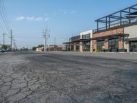 the empty street outside of the business district is empty and deserted with vehicles parked in it