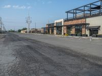 the empty street outside of the business district is empty and deserted with vehicles parked in it