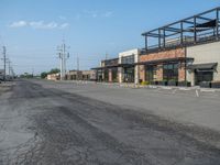 the empty street outside of the business district is empty and deserted with vehicles parked in it