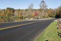 Asphalt Road with a Serene Water View and Trees