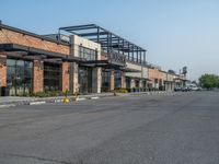 the empty street outside of the business district is empty and deserted with vehicles parked in it