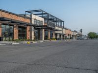 the empty street outside of the business district is empty and deserted with vehicles parked in it