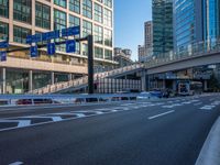 an empty road with a street sign at the curb in front of an office building