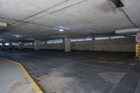 empty parking garage with a parking meter visible between it and the road closed to the public