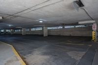 empty parking garage with a parking meter visible between it and the road closed to the public