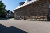 a man on a skateboard is riding on the street by an old stone building