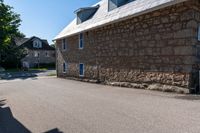 a man on a skateboard is riding on the street by an old stone building