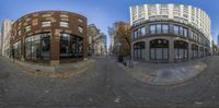 a small 360 - lens image shows a street and building in a city with tall windows