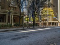 two benches on the side of a street in front of some tall buildings and buildings