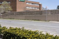 the stop sign stands for attention on a road corner in front of a brick building