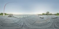 a view from a fish eye lens of a person riding on a skateboard on a boardwalk