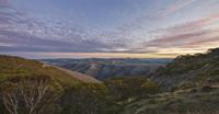 an image of mountains taken at sunrise time, with the sun setting in the distance