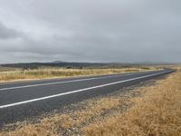 a lone empty highway with cloudy sky in the background for a postcarded photograph