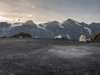 a black and white photo of a camp site and the mountains in the background as the sun sets