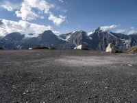 two rock - strewn mountains are seen with snow on them and rocks lying across from each other