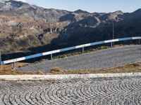 a view of the mountainous mountains and a train traveling along it, from above on a cobblestone road