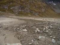 an image of a mountain scene with some rocks in the foreground and snow on top