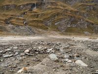 an image of a mountain scene with some rocks in the foreground and snow on top