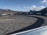 view from inside a vehicle at a stop and mountain top with buildings and road signs