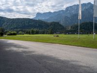 an empty street with flags on either side of the road and mountains in the background