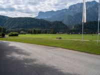 an empty street with flags on either side of the road and mountains in the background