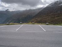 a lone skateboard parked in the middle of a road with mountains and foggy clouds