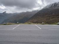 a lone skateboard parked in the middle of a road with mountains and foggy clouds