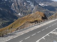 two cars parked on a paved road above the mountains with a traffic light next to the road