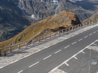 two cars parked on a paved road above the mountains with a traffic light next to the road