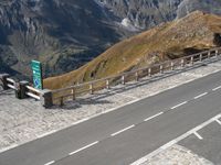 two cars parked on a paved road above the mountains with a traffic light next to the road