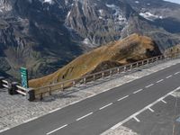 two cars parked on a paved road above the mountains with a traffic light next to the road