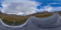 a 360 - eye view of a long curve in the middle of the mountain road