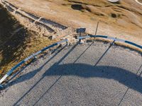 an aerial view of a park that is surrounded by hills and grass and rocks with an empty bench to the side