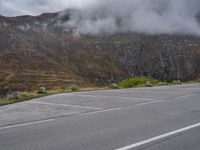 an open parking lot with mountains in the background on the side of the road in scotland