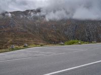 an open parking lot with mountains in the background on the side of the road in scotland