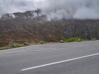 an open parking lot with mountains in the background on the side of the road in scotland