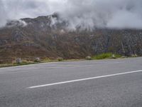 an open parking lot with mountains in the background on the side of the road in scotland