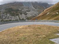 a person riding on the side of a mountain on a motor bike on a winding road