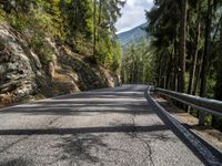 the road is going past some rocks and trees with two bikes on it that are also blocking the way