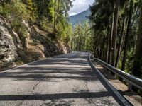 the road is going past some rocks and trees with two bikes on it that are also blocking the way