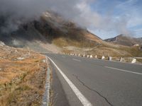 a highway on the side of a mountain under a cloudy sky with some clouds over it