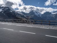 a sign on a highway warns drivers how to go ahead in the mountains below snow capped mountains