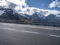 a sign on a highway warns drivers how to go ahead in the mountains below snow capped mountains