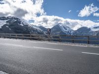 a sign on a highway warns drivers how to go ahead in the mountains below snow capped mountains