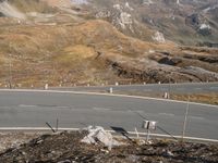 an aerial view of a hill with mountains in the distance and sign posts at the center of the road