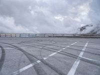 a train traveling over the top of an overpass next to a cloudy sky above