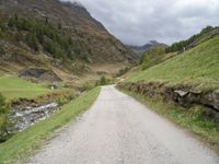 a small rural road surrounded by mountains and trees is pictured in this photo with a sky background