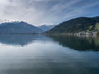 the mountain range is seen across the water, and the lake is calm and quiet